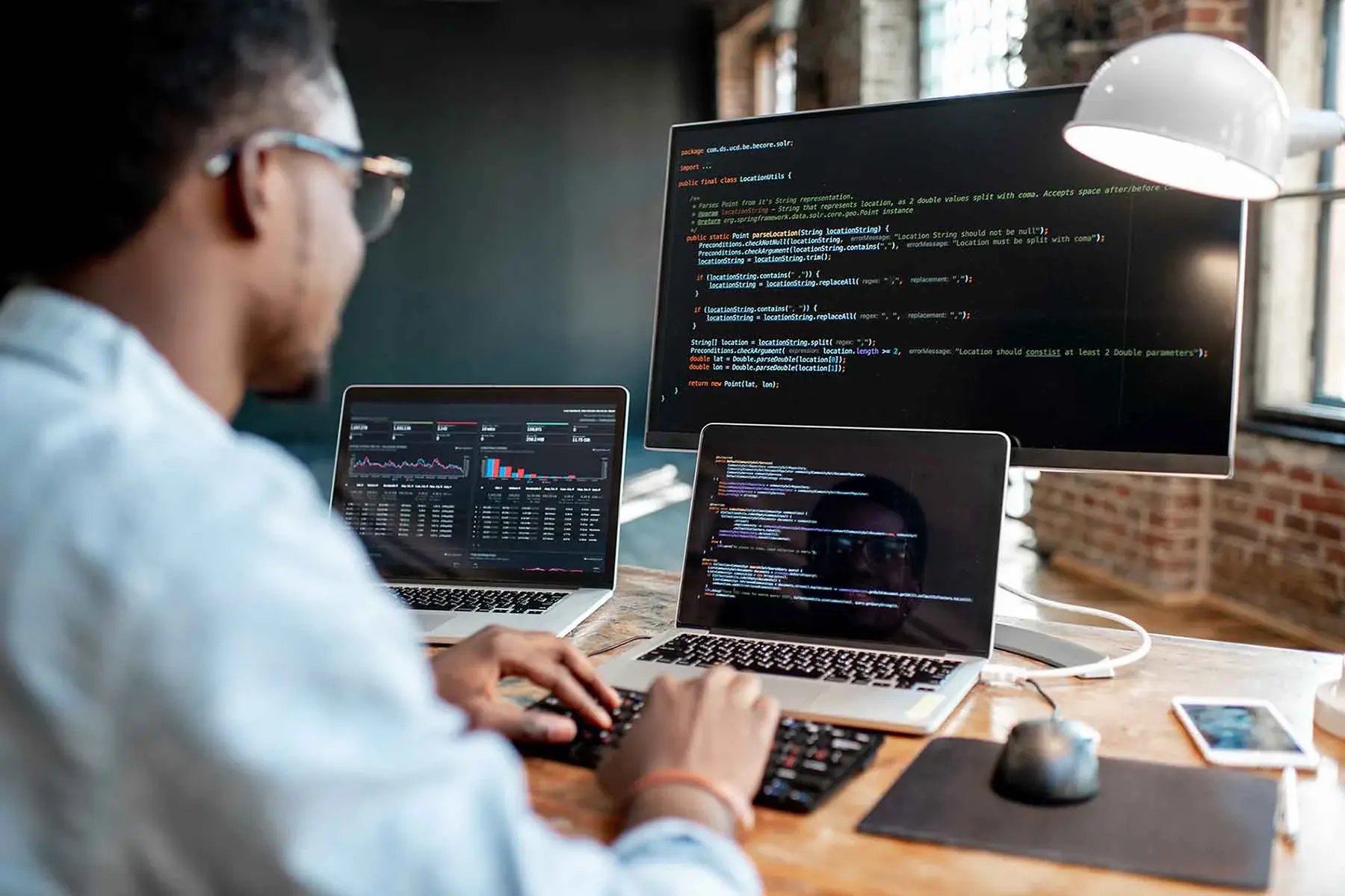 Man coding in multiple devices