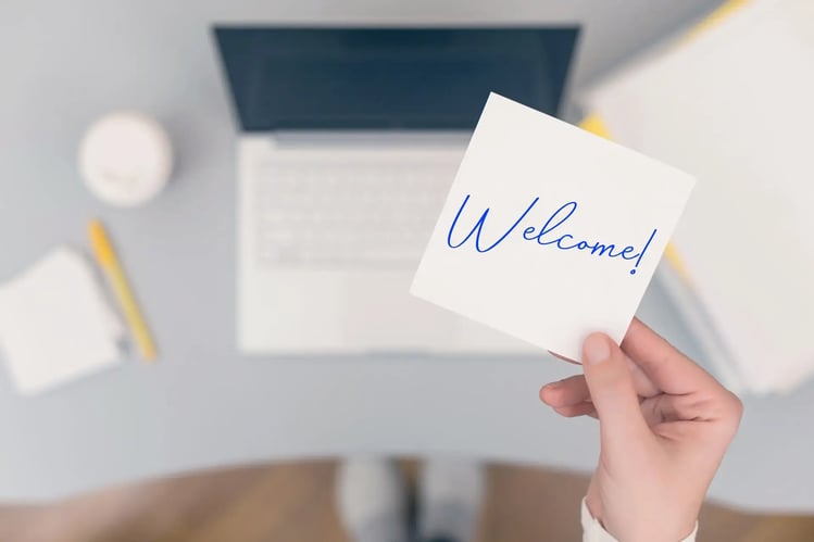 A welcome message on paper placed in front of a laptop, symbolizing readiness for immediate IT staff augmentation.