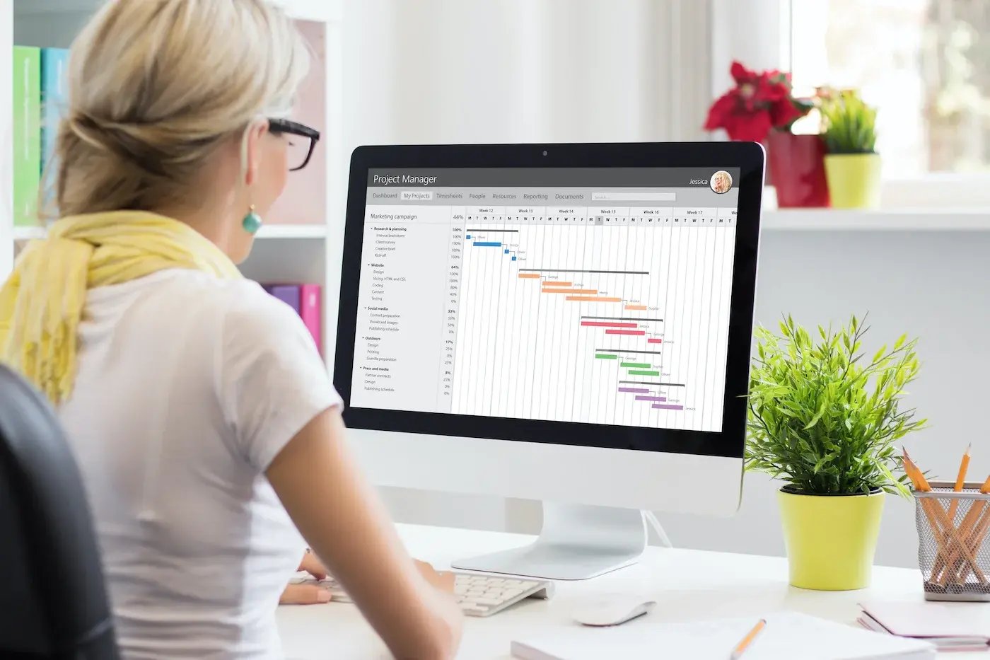 An agile coach reviewing a Gantt diagram on a desktop computer