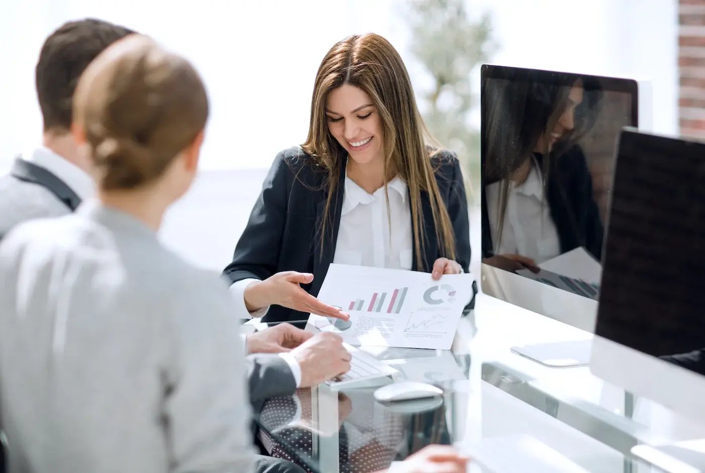 Woman presenting a report to other two people