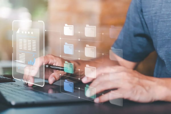 Person writing on a notebook with an hologram of files and a report.
