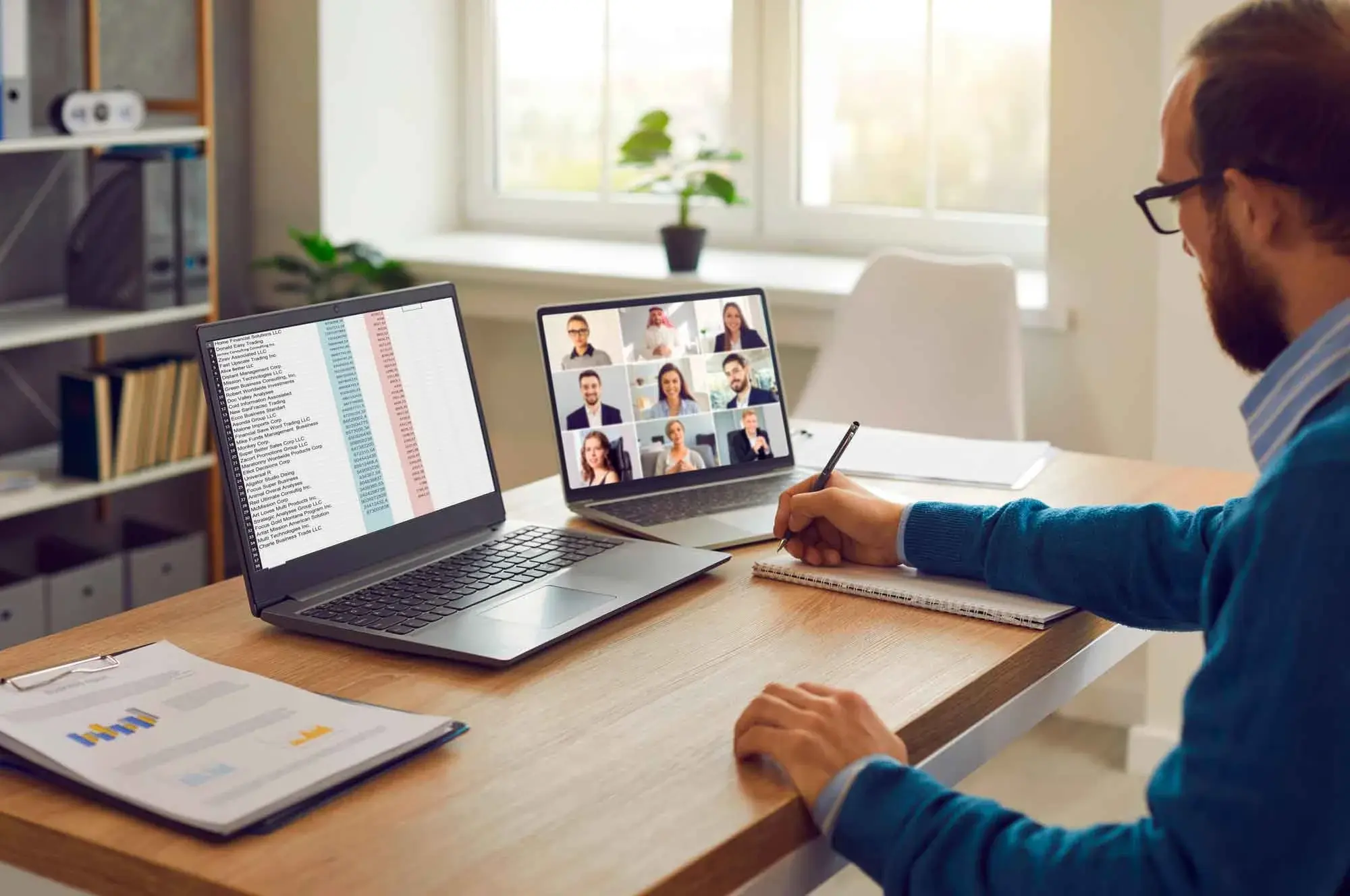 Man working on a home office with a laptop and a notebook with a meeting call.